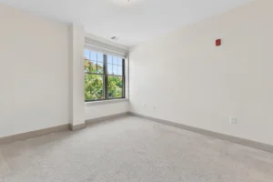 Carpeted bedroom with large window at 1580 River St #4D