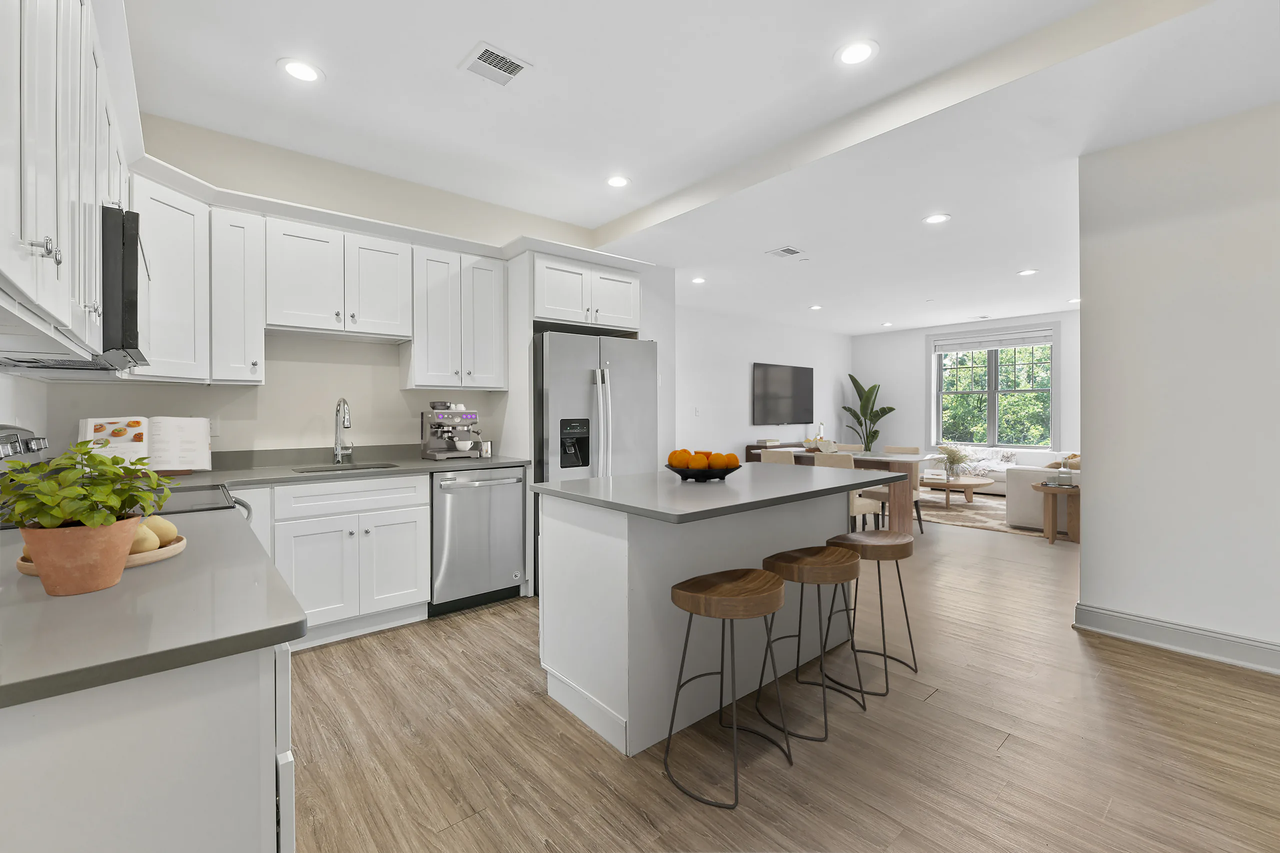 Virtually staged kitchen with breakfast island opening to the living room at 1580 River St #4D